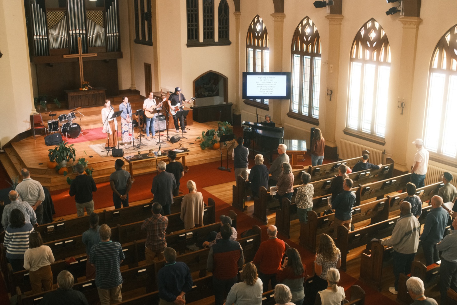 A congregation at worship in a historic sanctuary, seen from the balcony